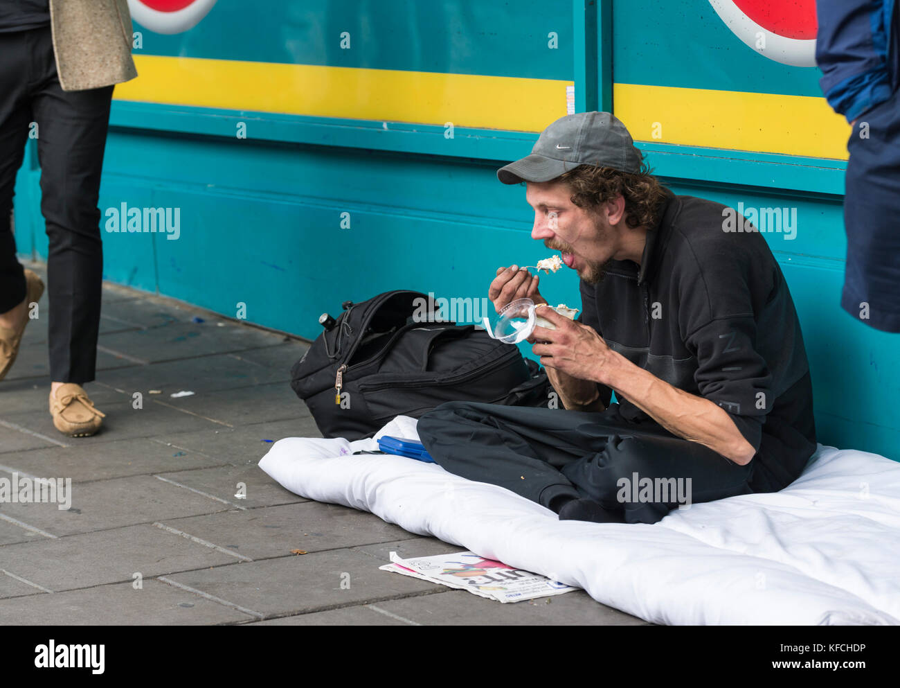 Obdachloser Verzehr einer Mahlzeit auf den Straßen in Brighton, East Sussex, England, UK. Stockfoto