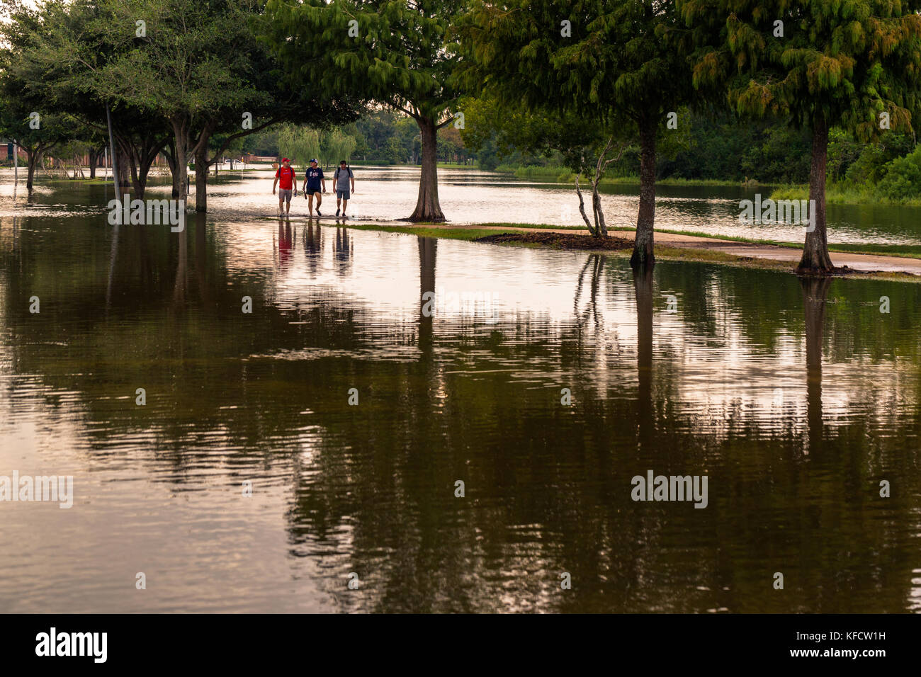 Bewohner von Sienna Plantage zu Fuß in die überfluteten Straße. Schwere Regenfälle vom Hurrikan Harvey verursacht viele Bereiche in Houston Vororten überflutet Stockfoto