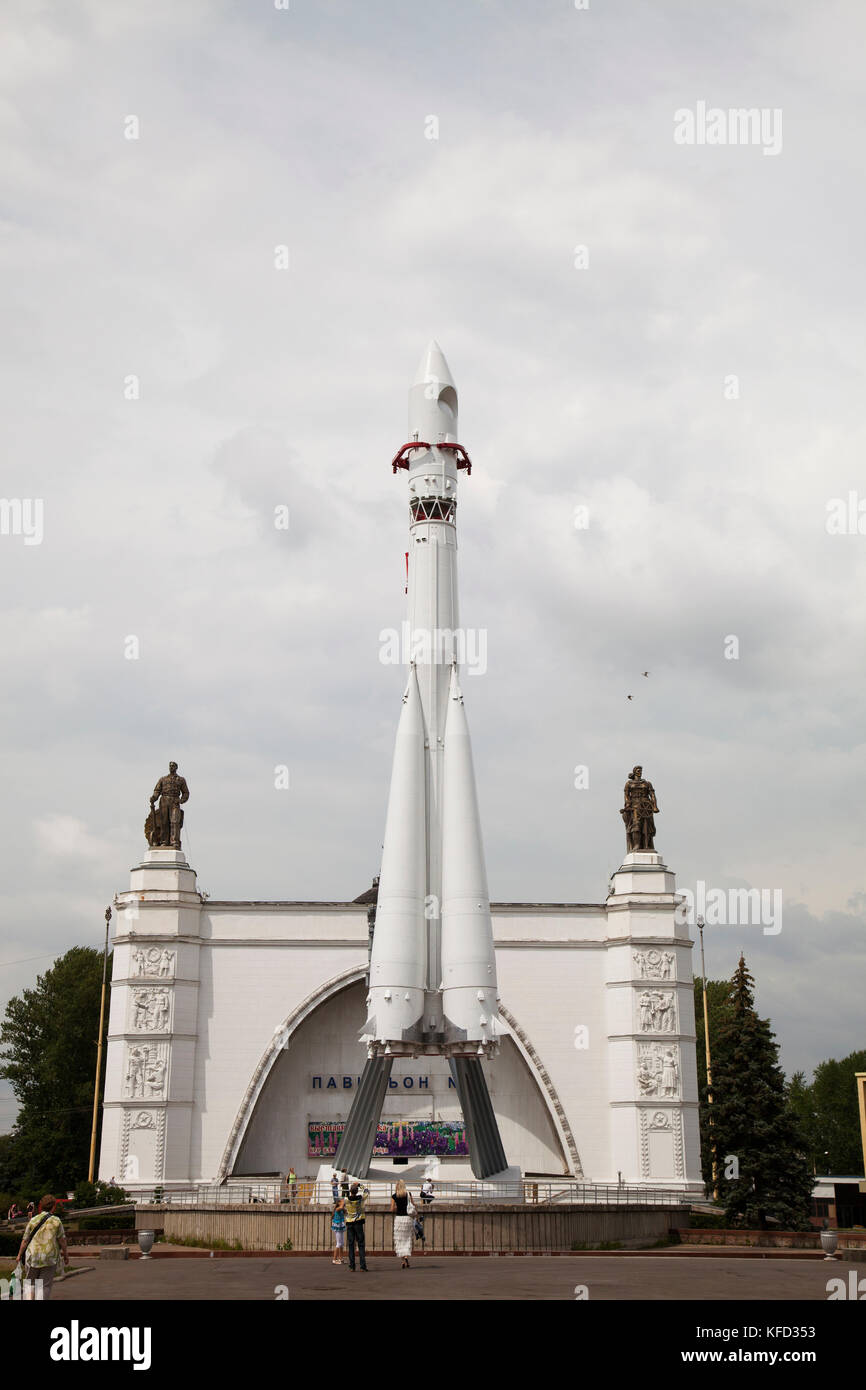 Russland, Moskau. Besucher im Space Pavilion mit einer Kopie der Wostok Rakete auf der Allrussischen Ausstellungszentrum. Stockfoto