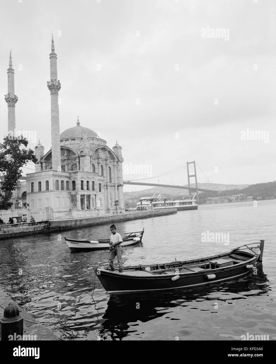 Türkei, Istanbul, junge stehend auf dem Boot mit Ortaköy Moschee im Hintergrund Stockfoto