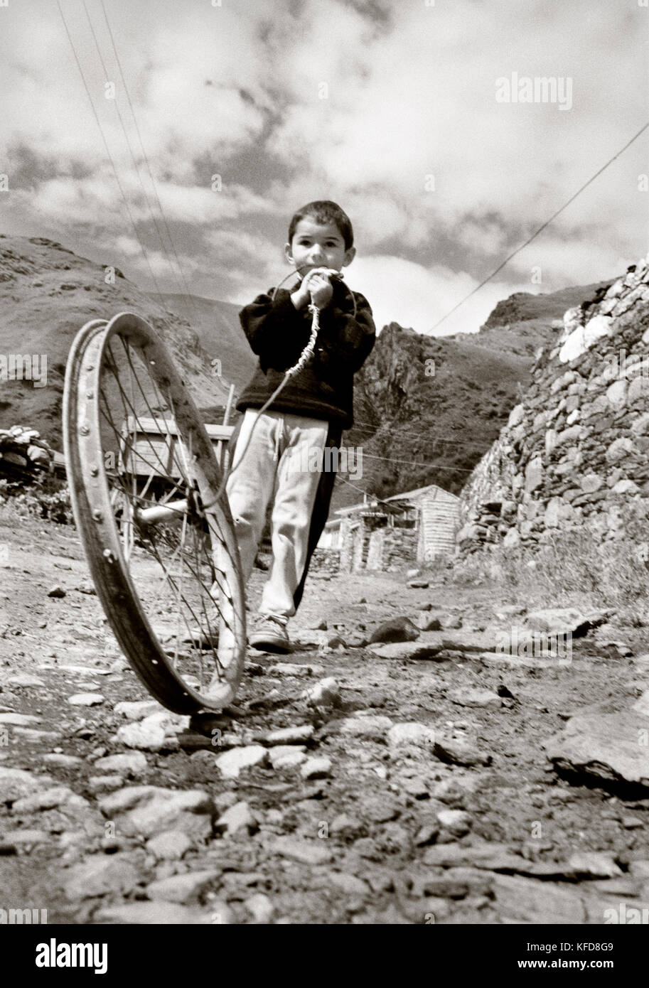 Republik Georgien, Junge spielt mit einem Spielzeug aus einem alten Fahrrad Felge (b&w) Stockfoto