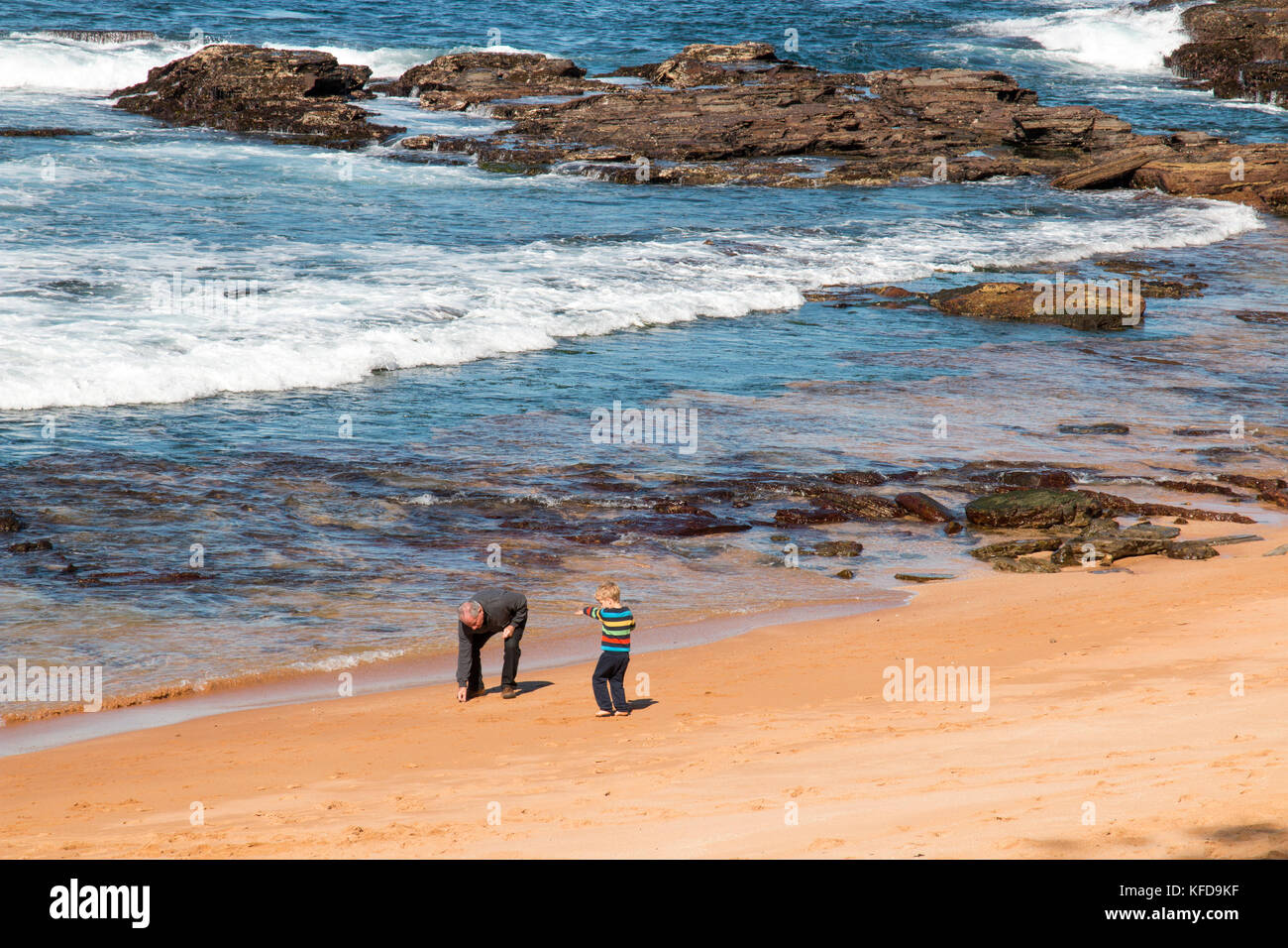 Großvater und Enkel spielen gemeinsam an einem Strand von Sydney, Australien Stockfoto