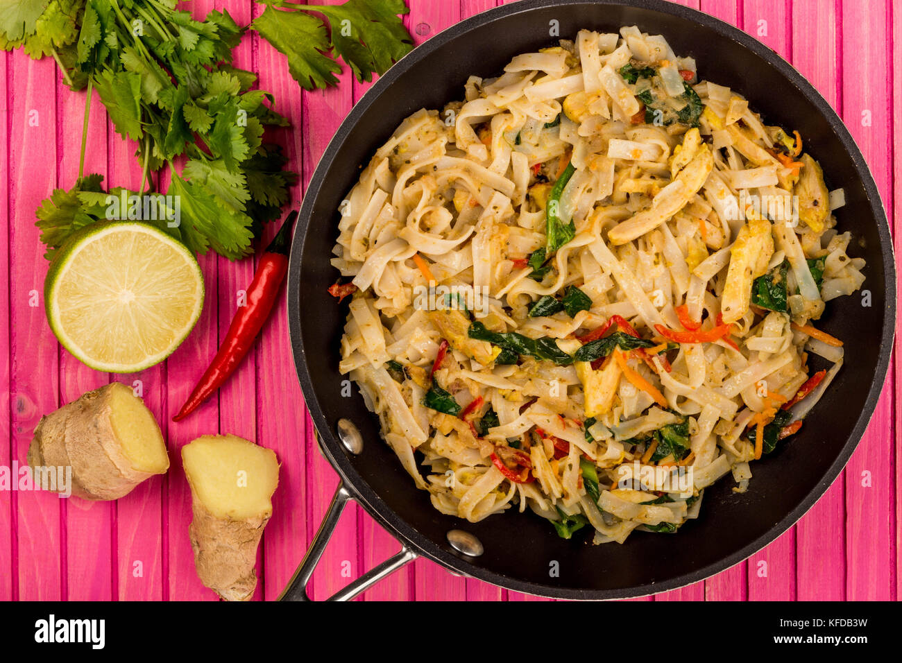 Im thailändischen Stil Huhn Pad Thai mit Nudeln auf einem rosa Hintergrund Holz Stockfoto