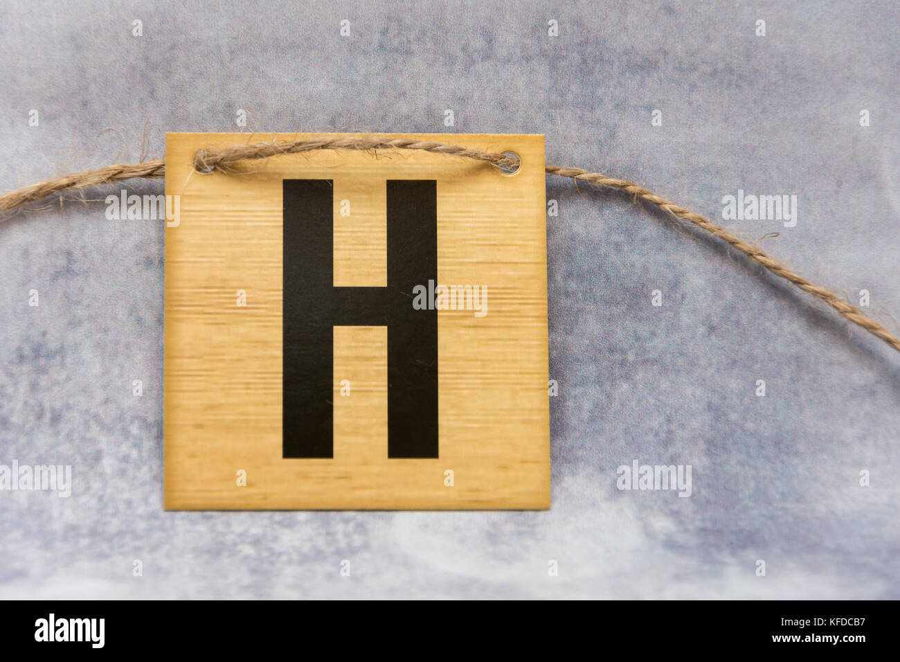 Isolierte Fliese Buchstaben des Alphabets auf einem gemusterten Hintergrund grau Stockfoto