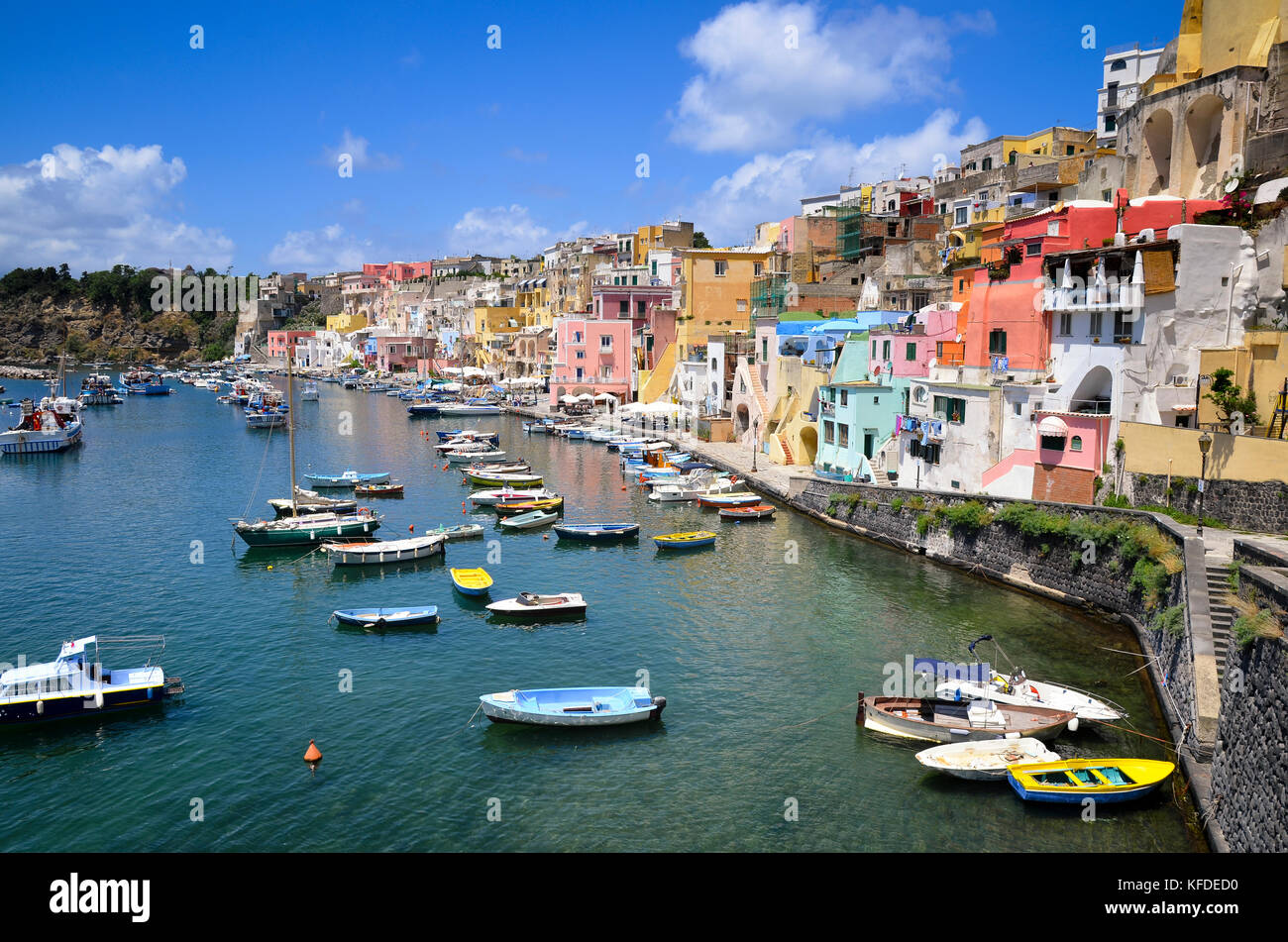 Hafen mit angelegten Boote und bunten waterfront Gebäude auf dem Hügel mit Blick auf das Wasser. Procida, in der Flegrean Inseln vor der coas Stockfoto