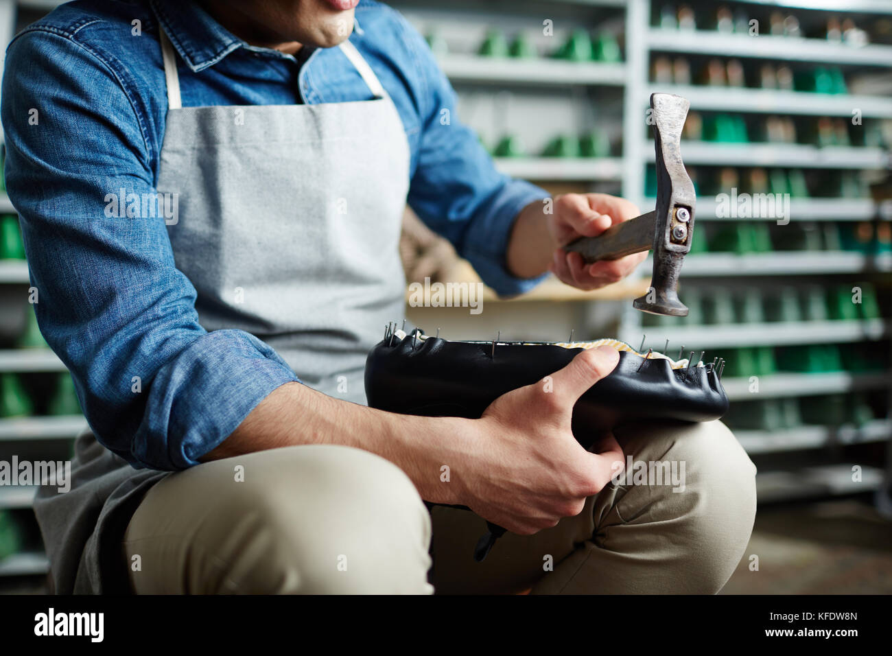 Professionelle Schuster hämmern Nägel in unfertigen Schuh in seiner Werkstatt Stockfoto