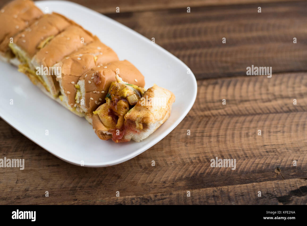 Malaysische Köstlichkeiten (roti John) - Brot mit Omelette in eine Platte auf einem Holztisch Stockfoto