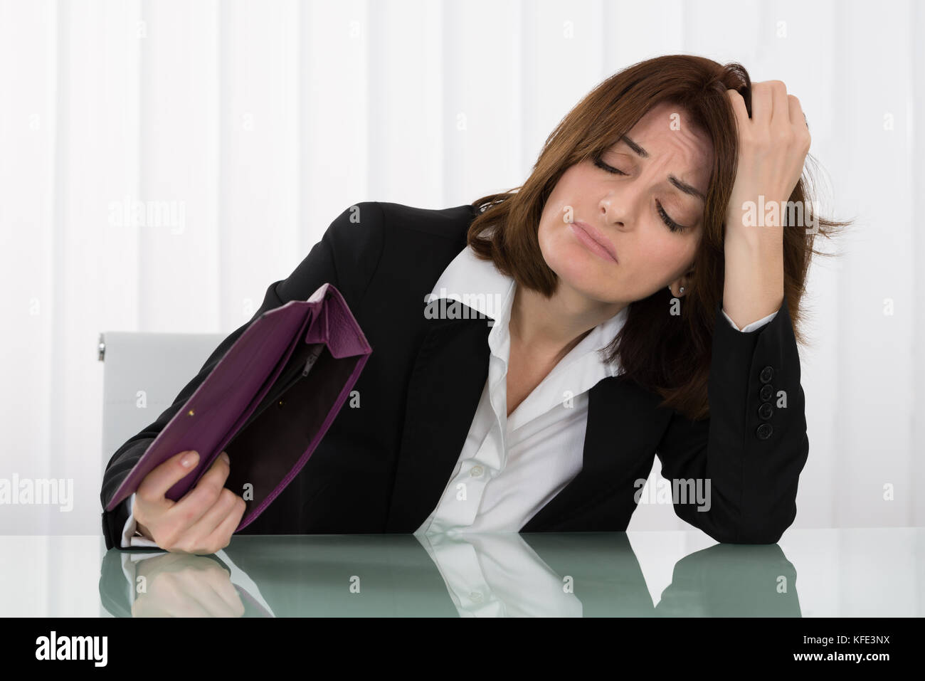 Traurige junge geschäftsfrau Holding leeren Geldbeutel am Schreibtisch Stockfoto
