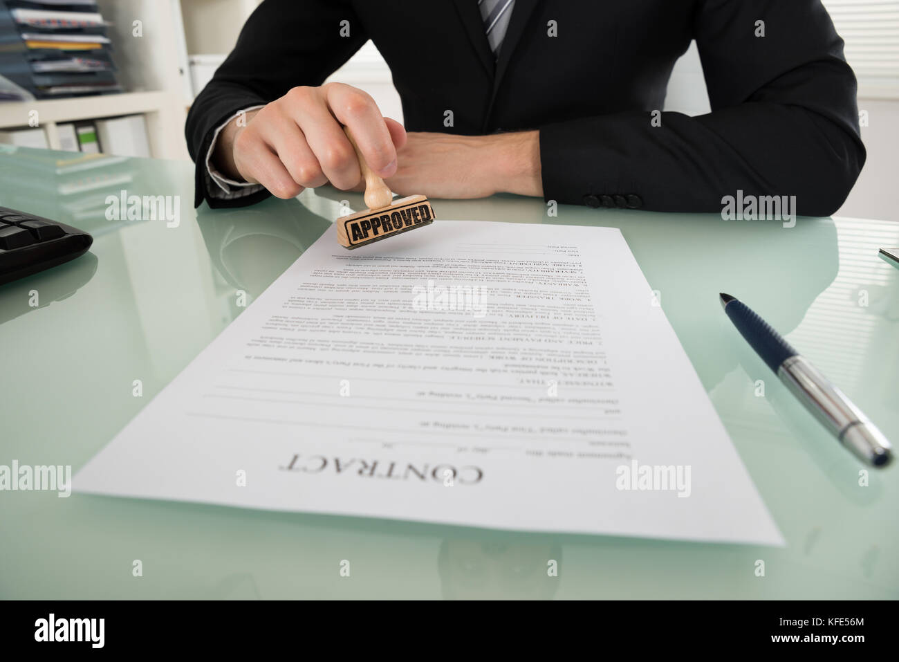 Nahaufnahme der Geschäftsmann hand Stanzen auf Vertrag Papier genehmigt Stockfoto