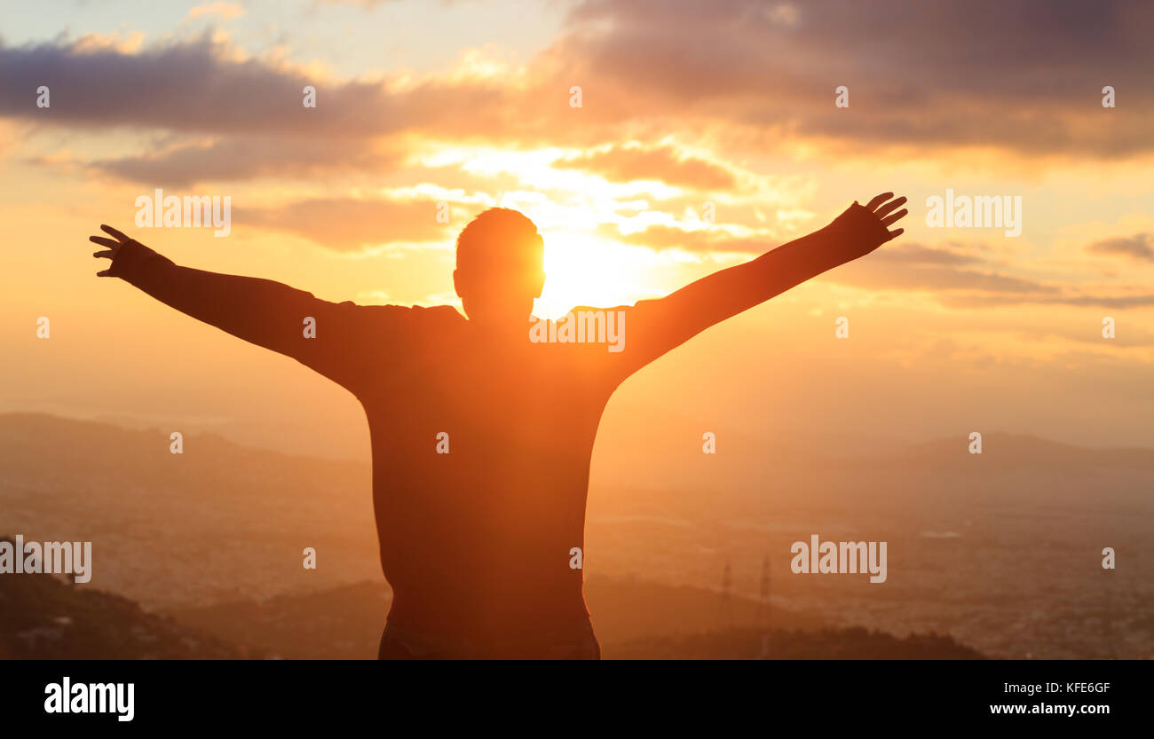 Silhouette der Mann mit offenen Händen im Golden Sun suchen. friedliche Aussicht. Stockfoto