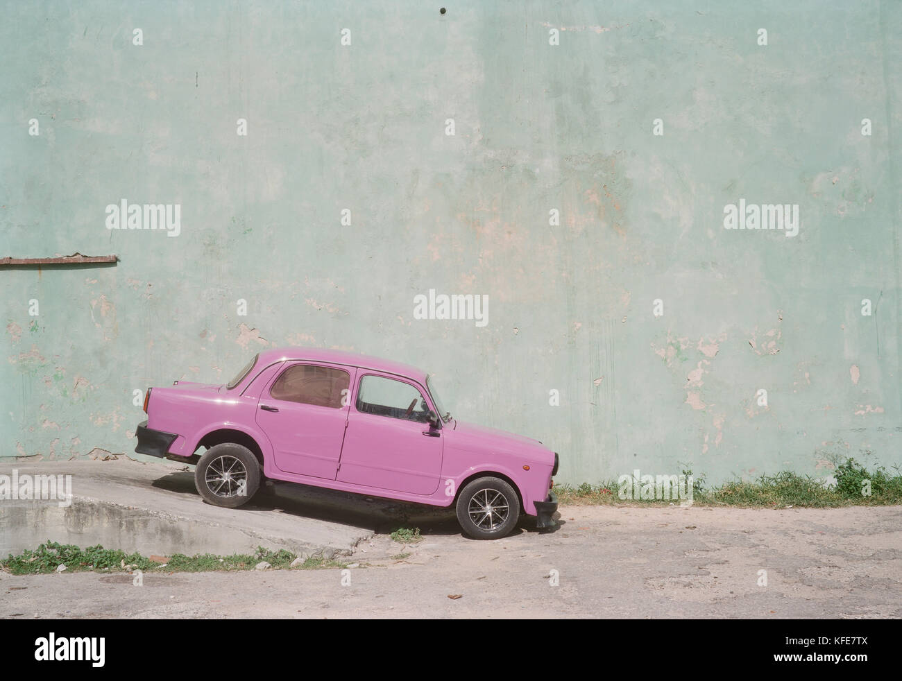 Eine alte Lila Wagen gegen eine Grüne Wand in Habana Vieja Stockfoto