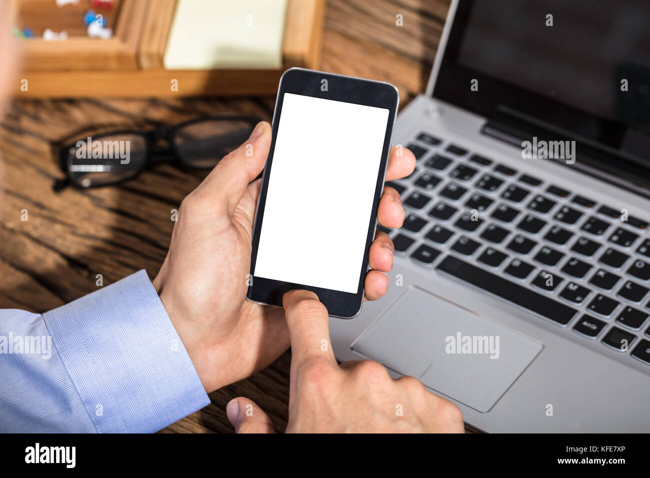 Nahaufnahme eines Kaufmanns Holding smart phone mit Leerer weißer Bildschirm Stockfoto
