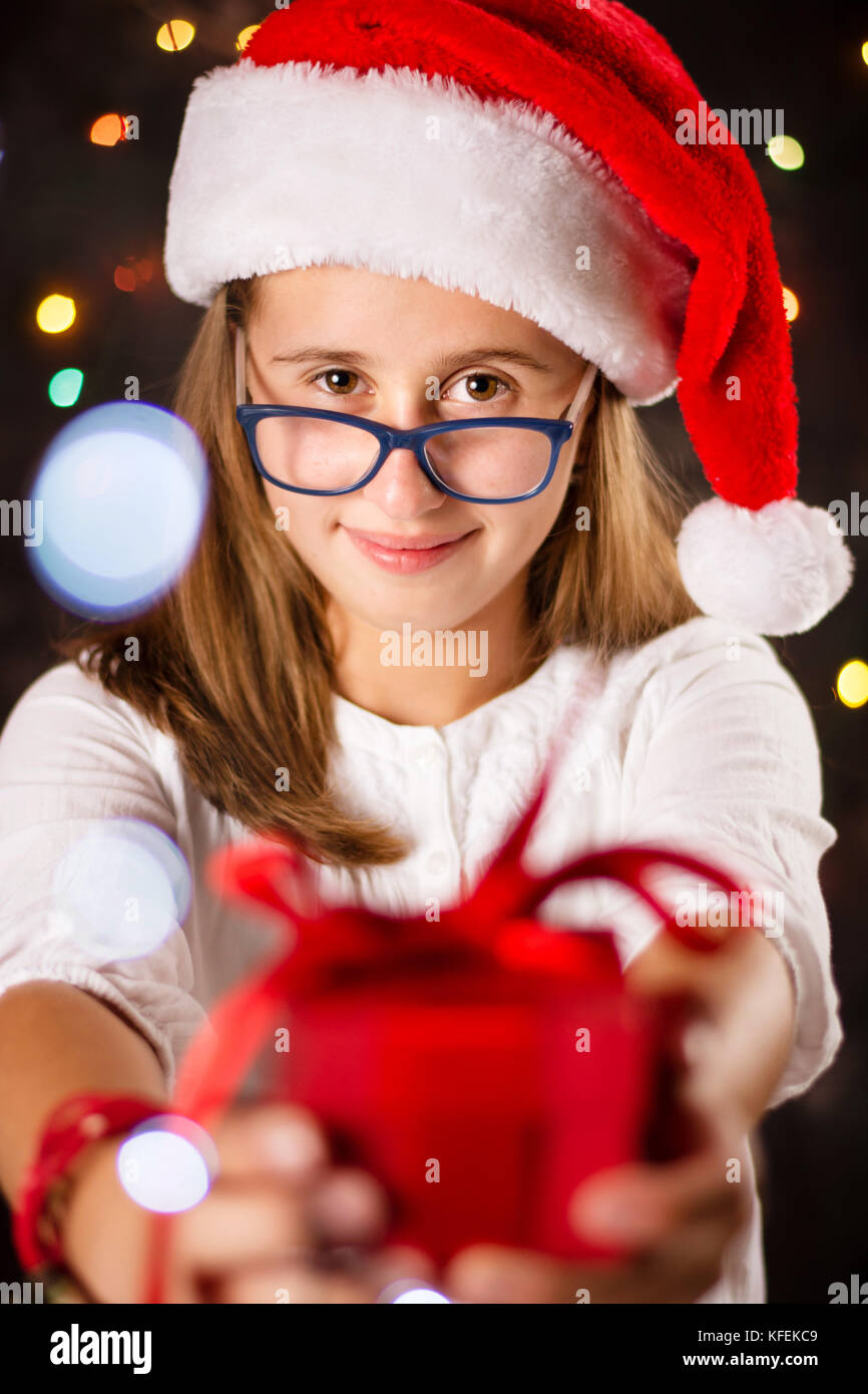 Junges Mädchen mit weihnachtsmütze Holding ein Geschenk Box Stockfoto