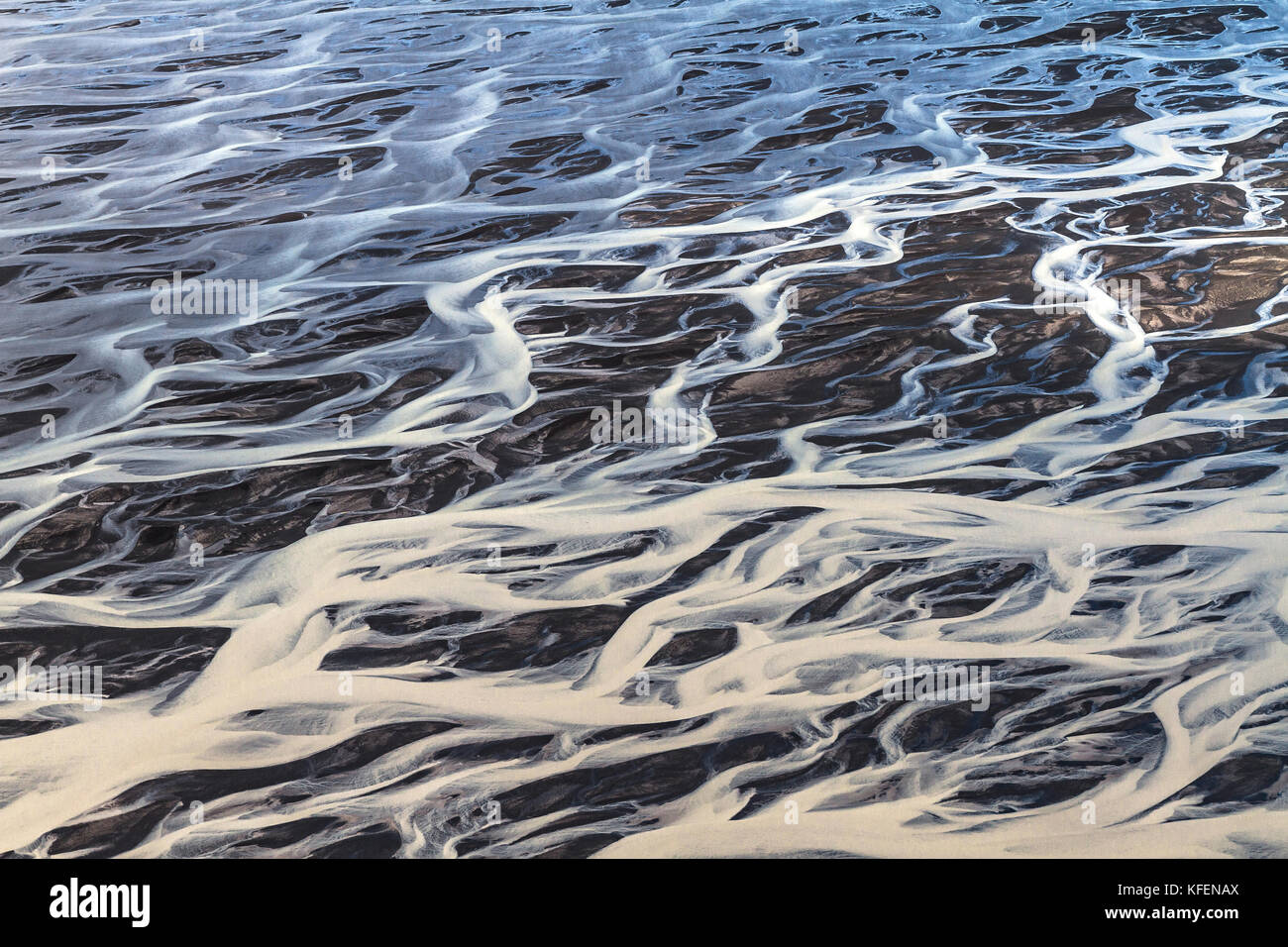 Fluss Formen in den schwarzen Sand Stockfoto