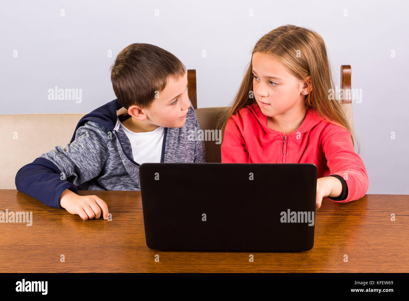 Kleine Jungen und Mädchen arbeiten auf einem Laptop. Stockfoto