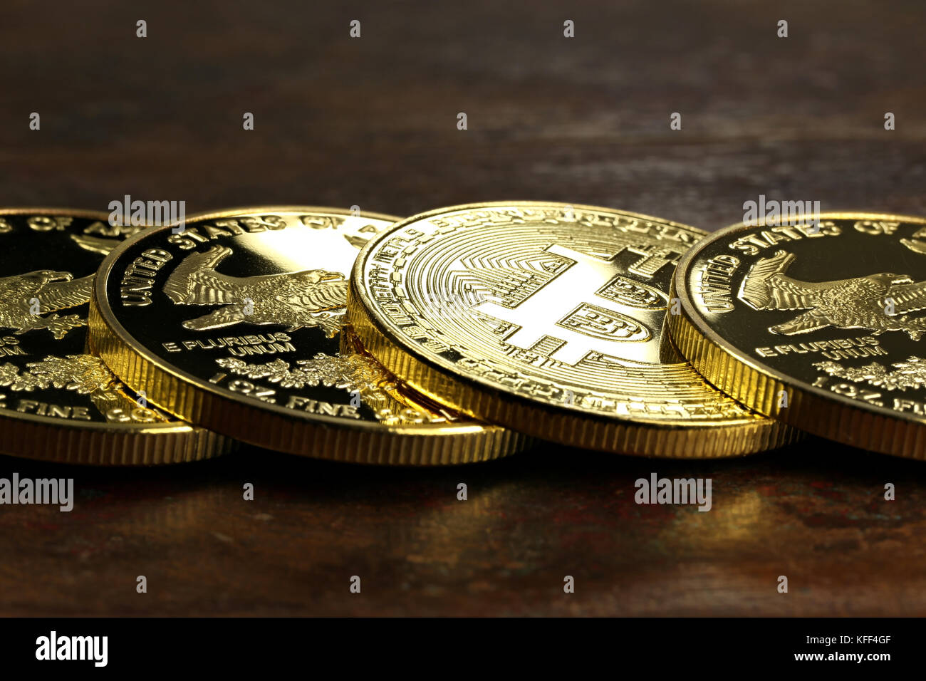 Bitcoin in einer Reihe von 1 Unze american Gold Eagle Bullion Coins Stockfoto