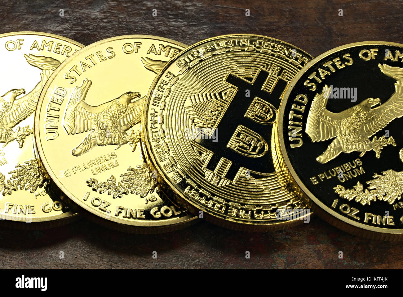 Bitcoin in einer Reihe von 1 Unze american Gold Eagle Bullion Coins Stockfoto