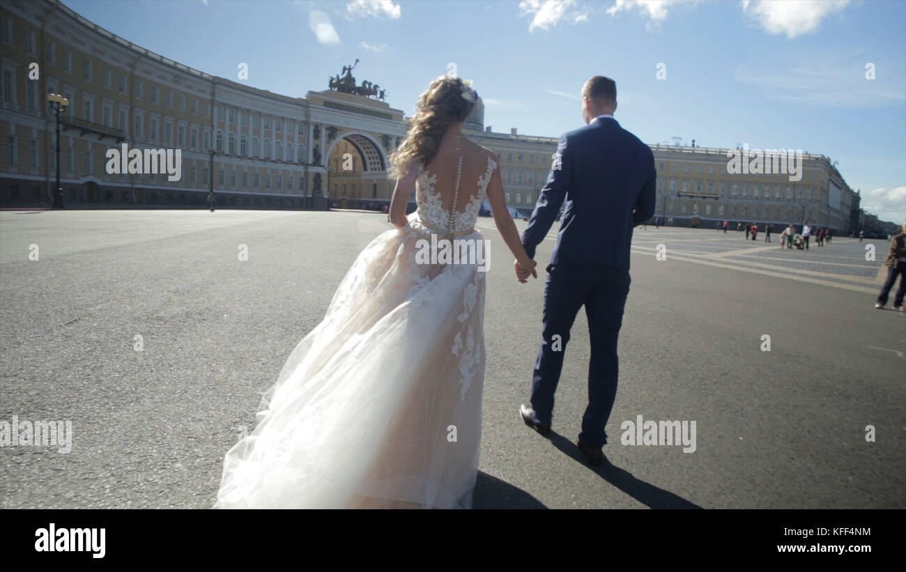 St. Petersburg, Russland Braut und Bräutigam entlang wandern. Die Braut und der Bräutigam Spaziergang auf dem Platz in der Nähe des Winterpalais und halten sich an den Händen. Braut und Bräutigam, Hände weg auf Platz von Sankt Petersburg Stockfoto