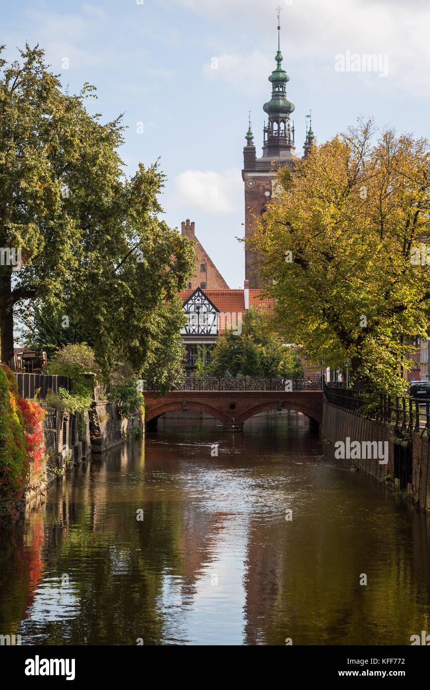 Blick auf einen idyllischen Kanal, liebe Brücke und Kirche an einem sonnigen Tag in Danzig, Polen, im Herbst. Stockfoto