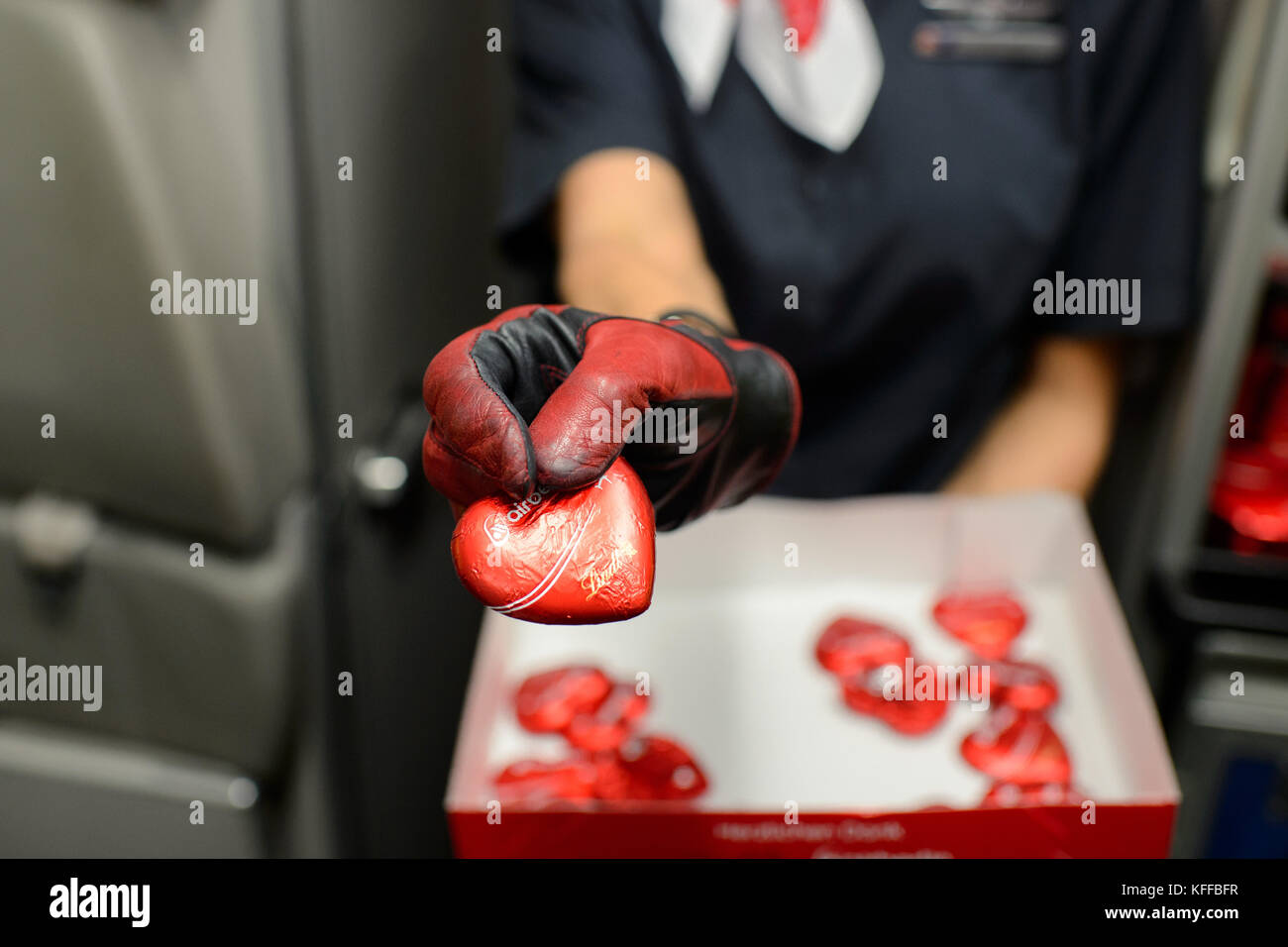 München, Deutschland. Oktober 2017. Ein Air Berlin Steward mit Schokolade auf dem letzten Flug des insolventen Luftfahrtkonzerns in München, Deutschland, 27. Oktober 2017. Nach dem letzten Flug von München zum Berliner Flughafen Tegel stellte das Unternehmen alle Dienste ein. Quelle: Gregor Fischer/dpa/Alamy Live News Stockfoto