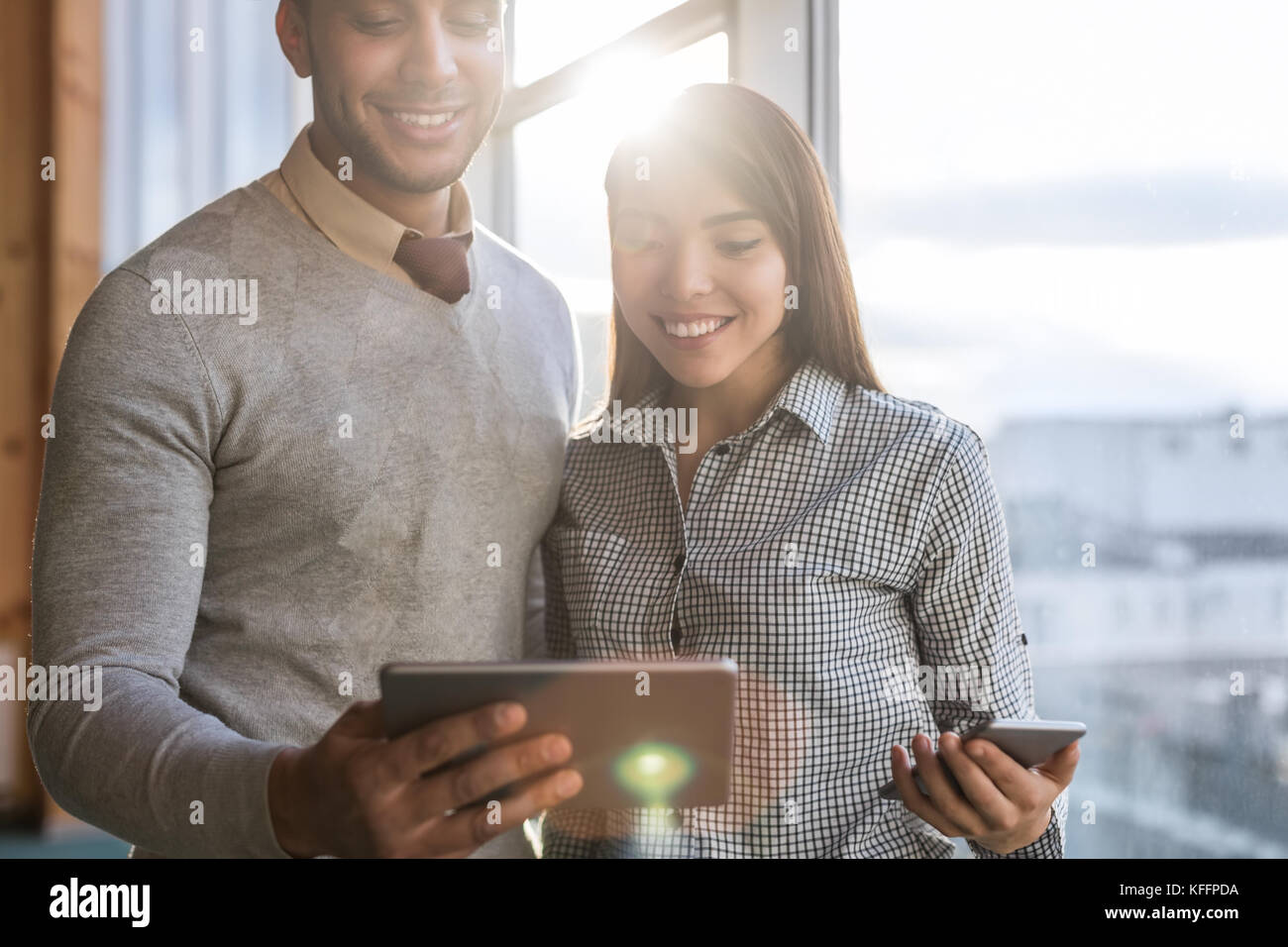 Mix Rennen business Mann Frau mit Zelle smart phone vor panoramafenster Glücklich lächelnde Geschäftsleute Stockfoto