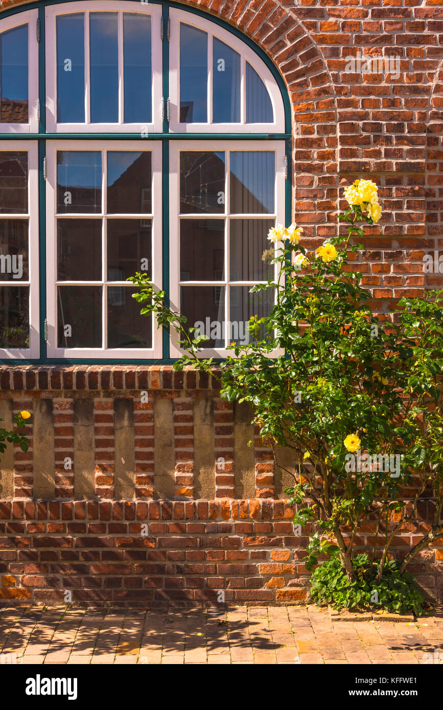 Gewölbte Fenster von einem alten Backsteingebäude der Stadt Husum an der Nordsee, Deutschland Stockfoto