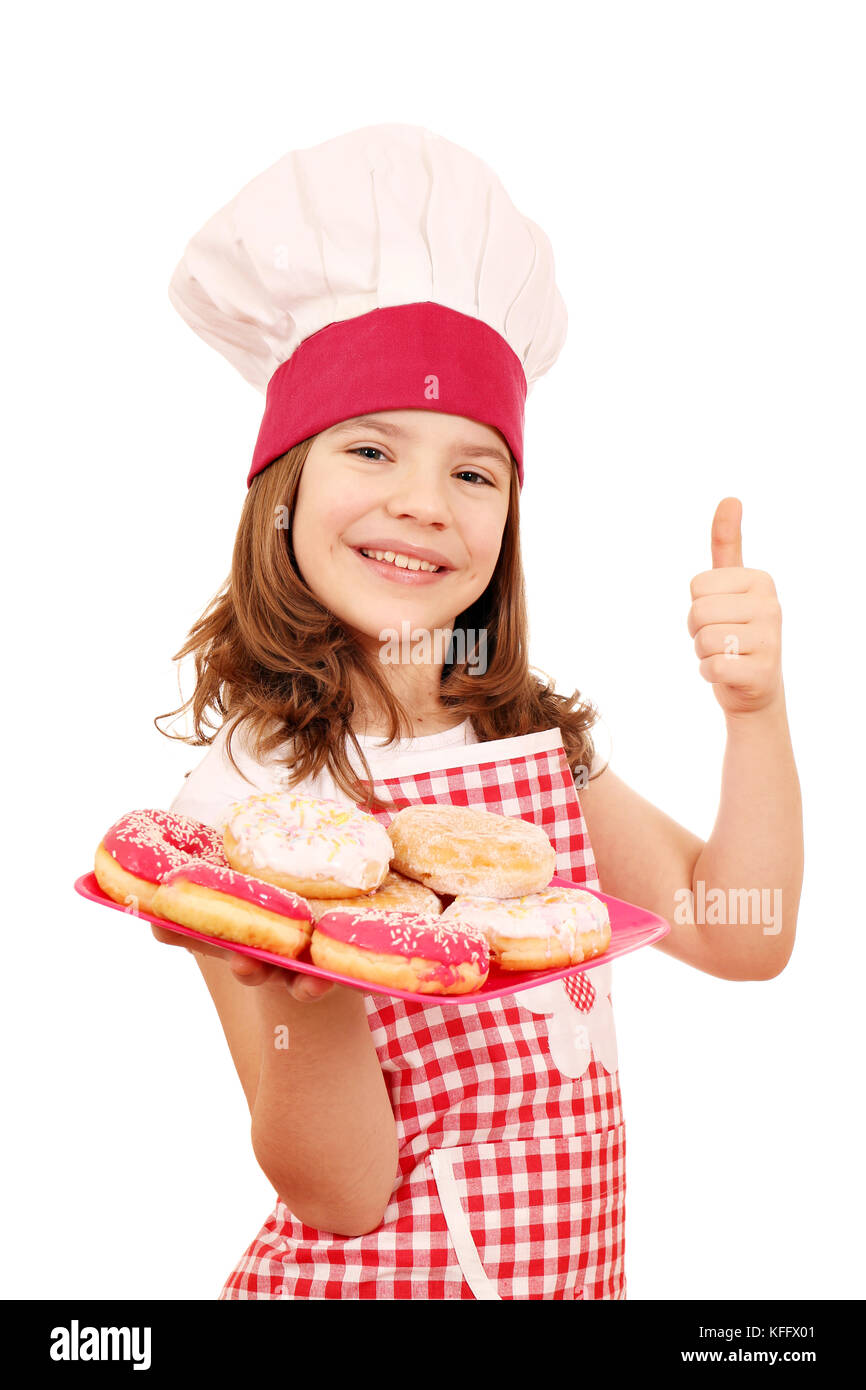 glückliches kleine Mädchen Kochen mit Donuts und Daumen Stockfoto