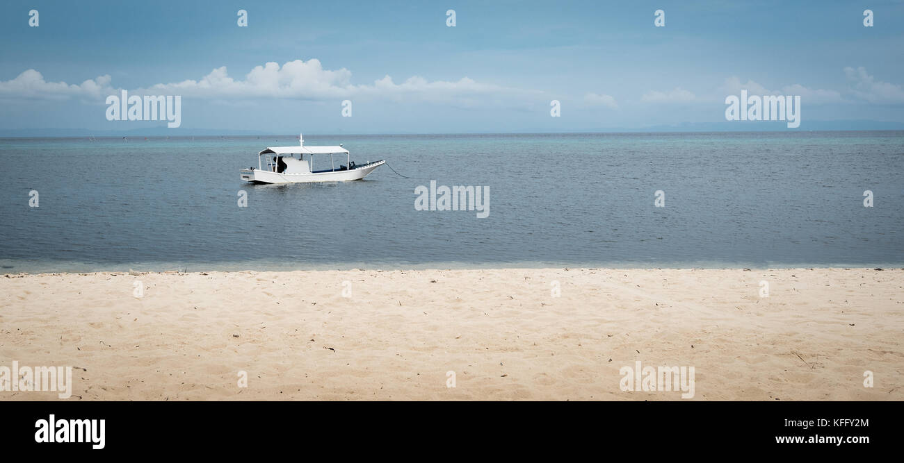 Ein einzelnes Boot im Wasser auf eine ruhige See auf der philippinischen Insel Malapascua Stockfoto