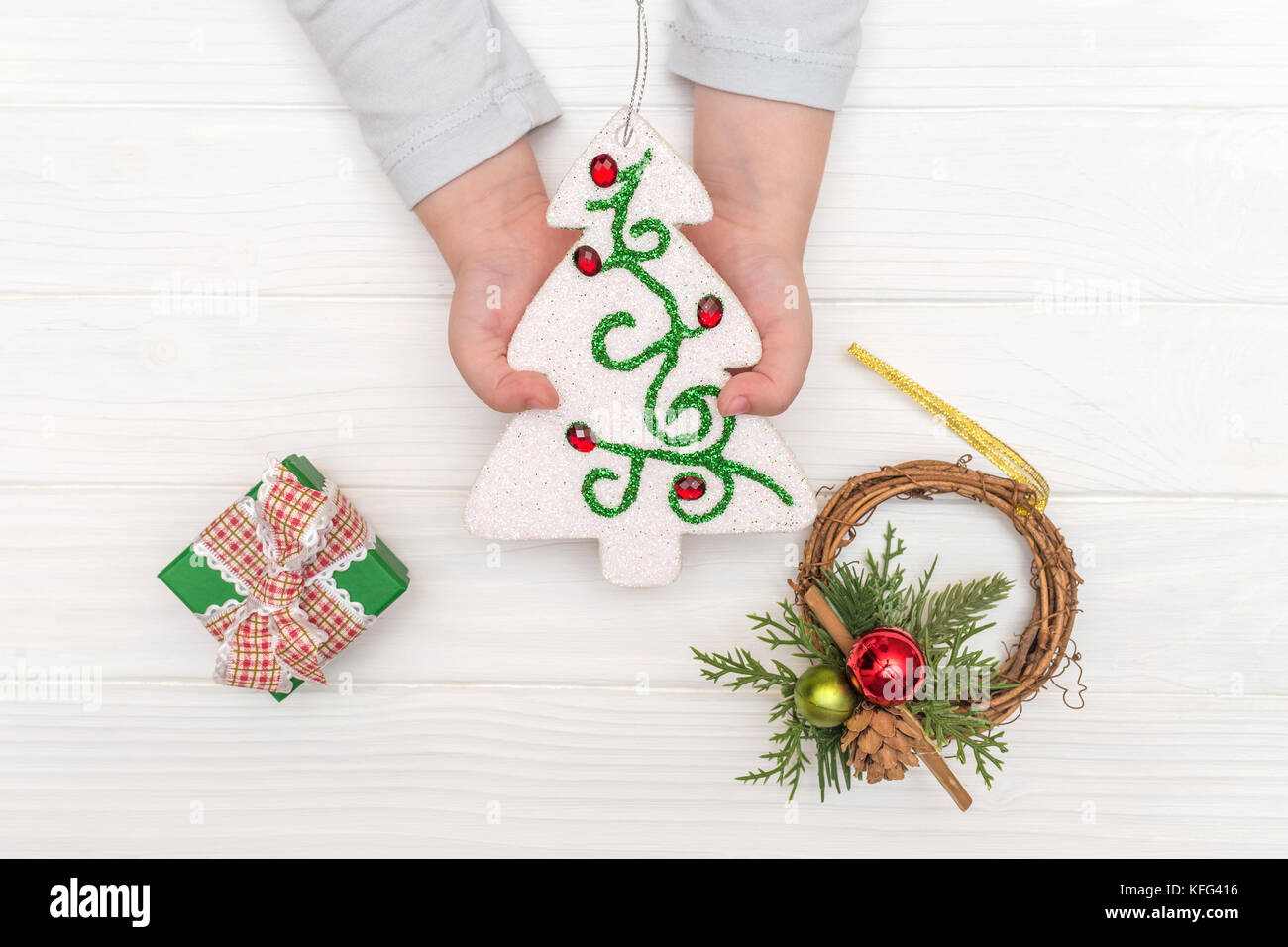 Weihnachten Kalender auf weißem Hintergrund. Child's Hände, die ornamentalen Weihnachtsbaum in der Nähe von geschenkboxen auf weißen Tisch Stockfoto