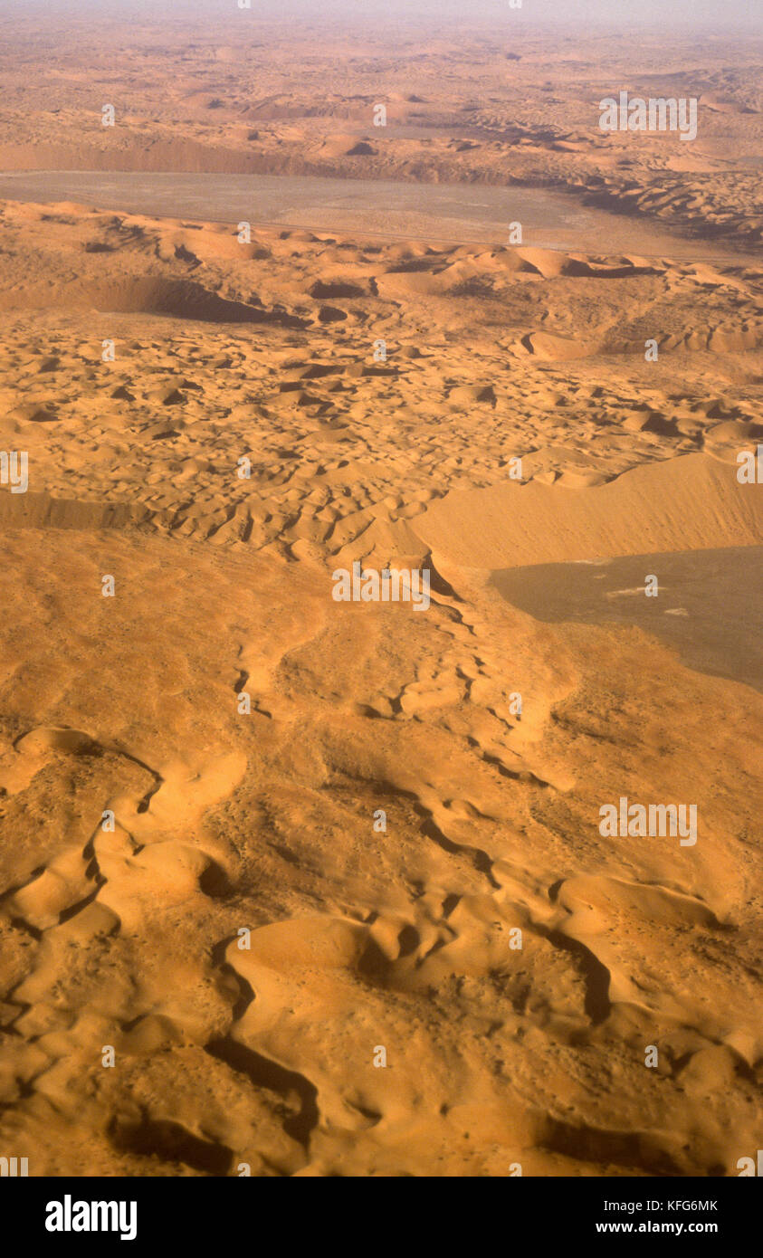 Luftaufnahme der massiven roten Dünen und sabkha Wohnungen in der Nähe der Shaybah Gas öl Luftzerlegungsanlage (gosp), eine große Gas-, Öl- und Produktionsstätte in das Leere Viertel Wüste Saudi Arabiens, in der Nähe der Grenze zu den Vereinigten Arabischen Emiraten. Stockfoto