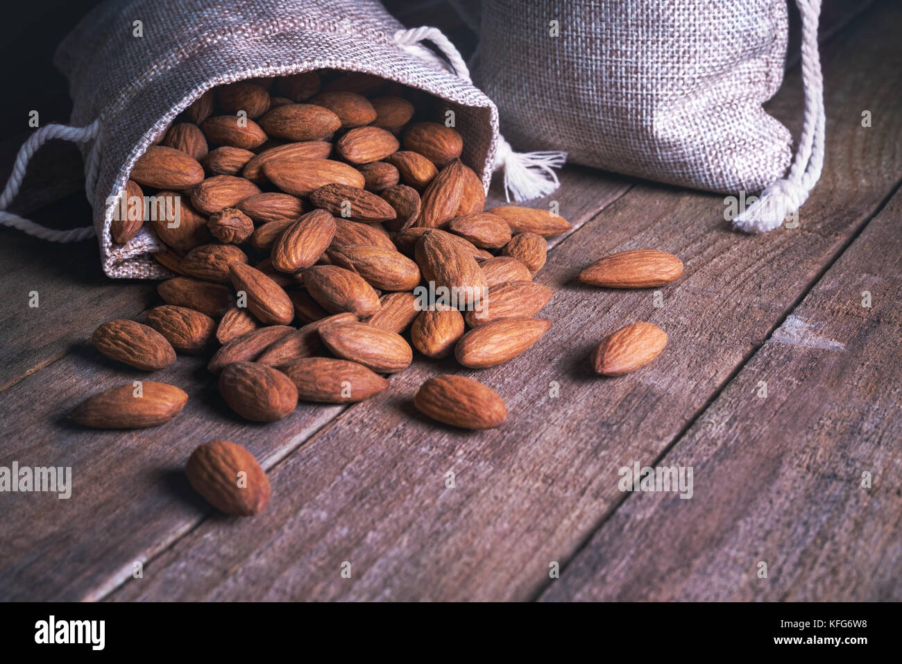 Eine Menge Mandeln fallen aus dem Stoffbeutel. Stockfoto