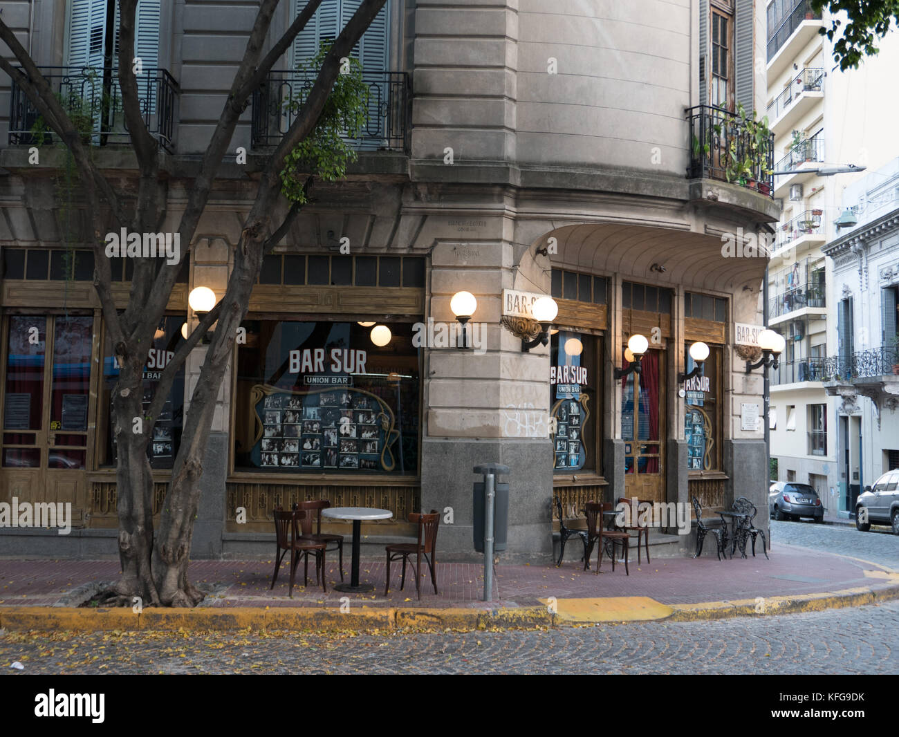 Leere Tische vor der alten, traditionellen lokalen San Telmo Bar, die sich in Buenos Aires. Kugel- auf alten Holztüren und leere Straße. Stockfoto