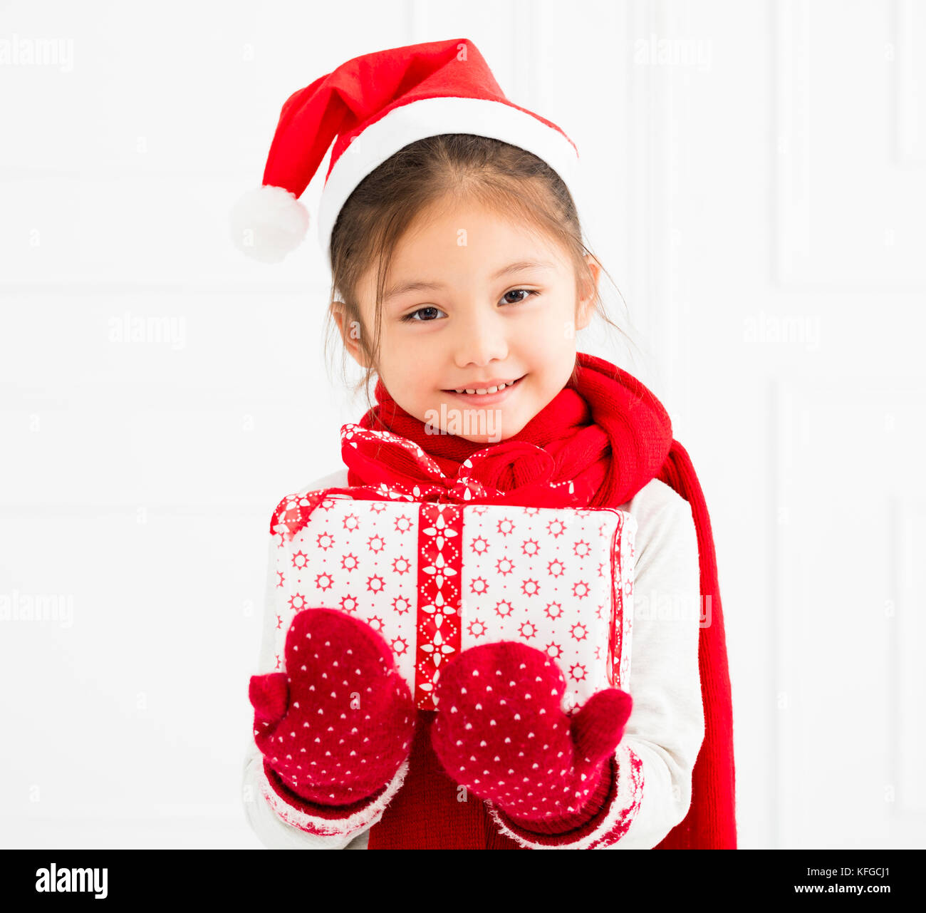 Gerne kleine Mädchen mit Weihnachtsgeschenk Stockfoto