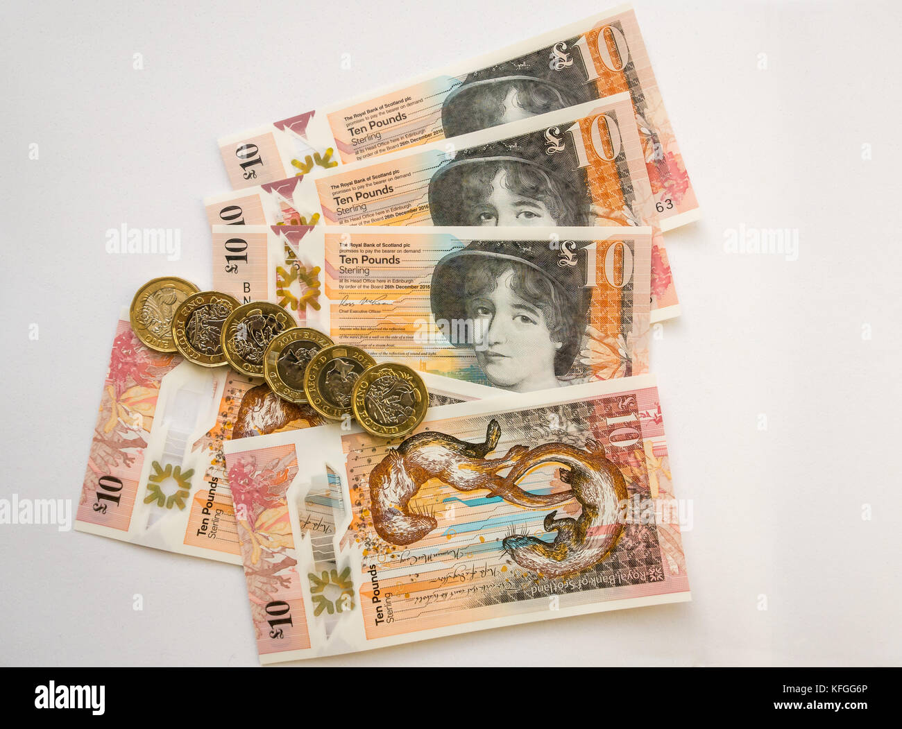 Royal Bank of Scotland neue Kunststoff Polymer zehn Pfund £ 10 Banknoten- und neuen sechseckigen ein Pfund £ 1 Münzen, auf einem weißen Hintergrund Stockfoto