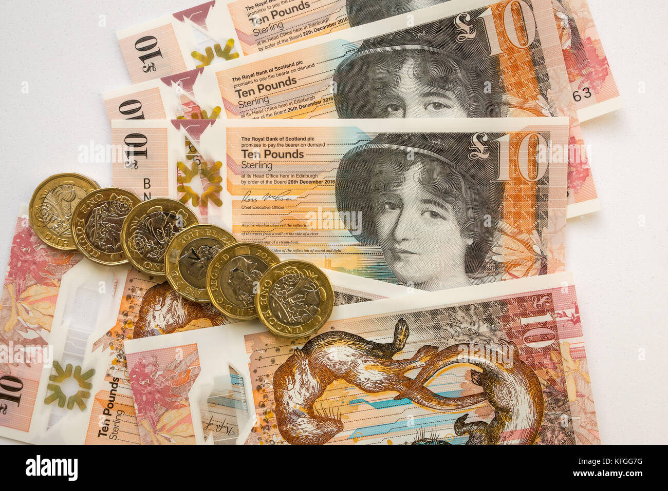 In der Nähe von Royal Bank of Scotland neue Kunststoff Polymer zehn Pfund £ 10 Banknoten- und neuen sechseckigen ein Pfund £ 1 Münzen, auf weißem Hintergrund Stockfoto