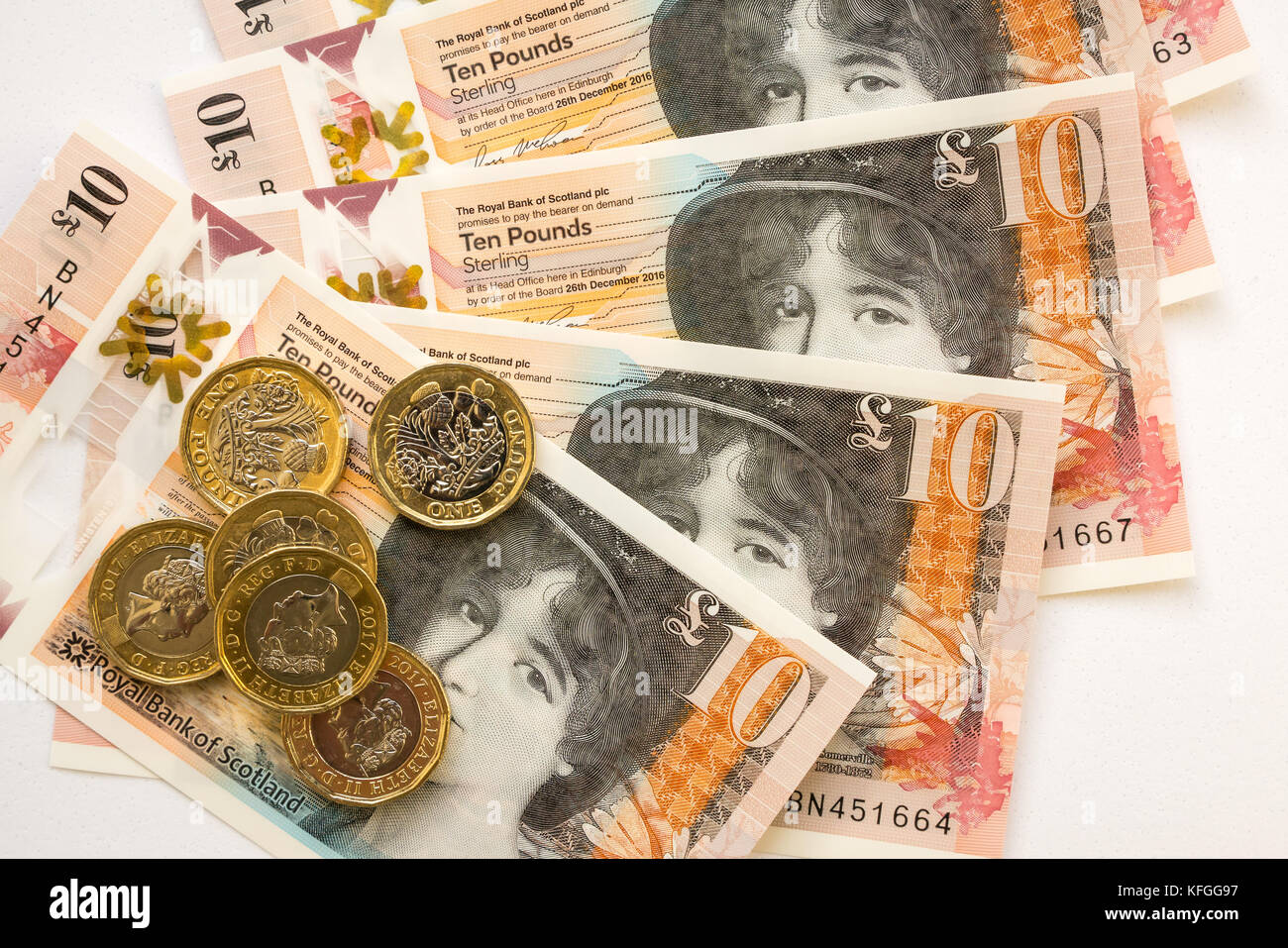 In der Nähe von Royal Bank of Scotland neue Kunststoff Polymer zehn Pfund £ 10 Banknoten- und neuen sechseckigen ein Pfund £ 1 Münzen auf weißem Hintergrund Stockfoto