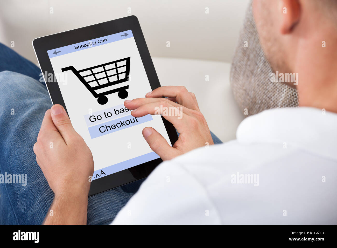 Konzeptuelles Bild eines Mannes, der auf seinem Tablet-Computer einen Online-Kauf getätigt hat, mit einer Ansicht des Bildschirms, auf dem ein Einkaufswagen und der Text zur Überprüfung angezeigt werden Stockfoto