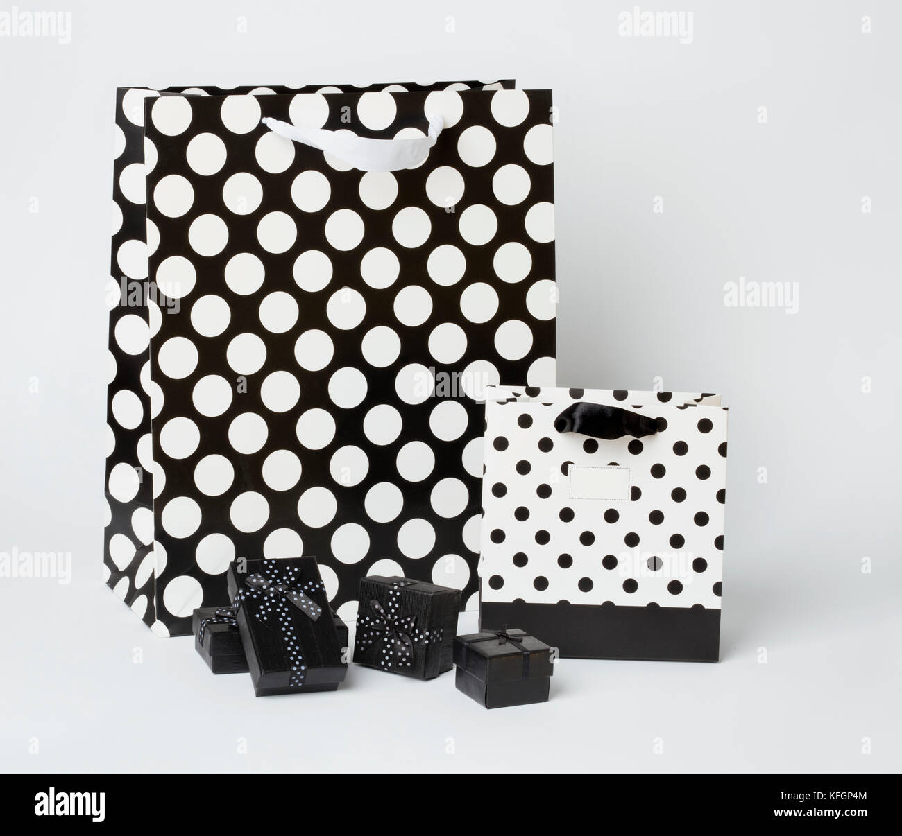 Klein, schwarz Geschenk-Boxen mit schwarzen und weißen Geschenk - Taschen mit Polka Dots, auf weißem Hintergrund. Stockfoto
