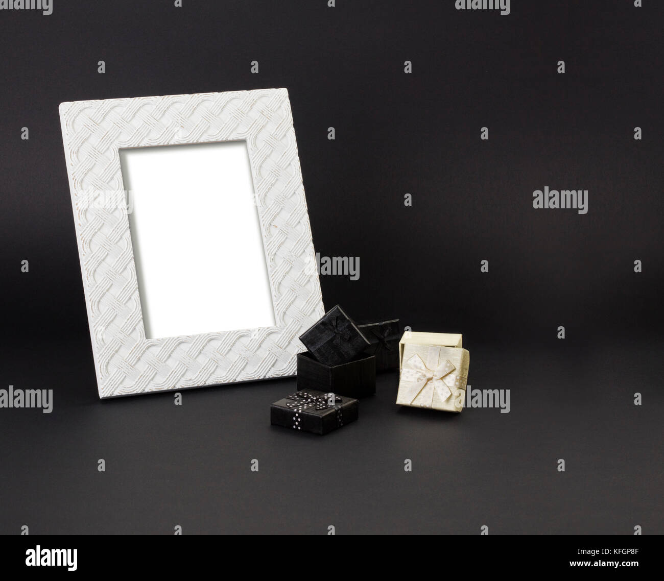 Weiß Foto-Frame auf schwarzem Hintergrund, mit einem kleinen Geschenk-Boxen in Schwarz und Weiß. schwarzen Hintergrund. Stockfoto