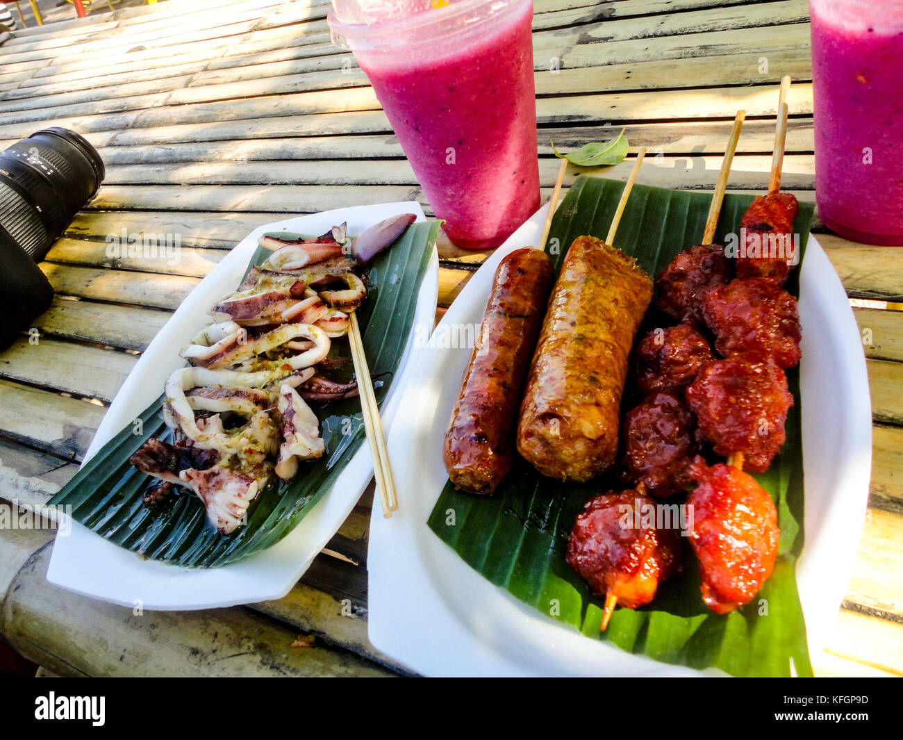 Thai Street Food. Gegrillter Tintenfisch, Schweinefleisch und Wurst mit Dragon Fruchtshake Stockfoto