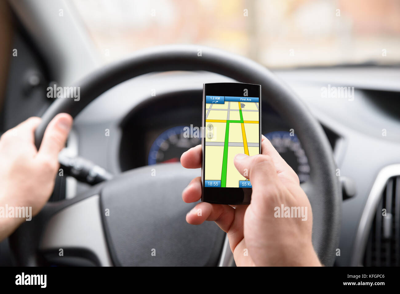 Nahaufnahme des Mannes mit GPS-Navigation im Mobiltelefon während der Fahrt mit dem Auto Stockfoto