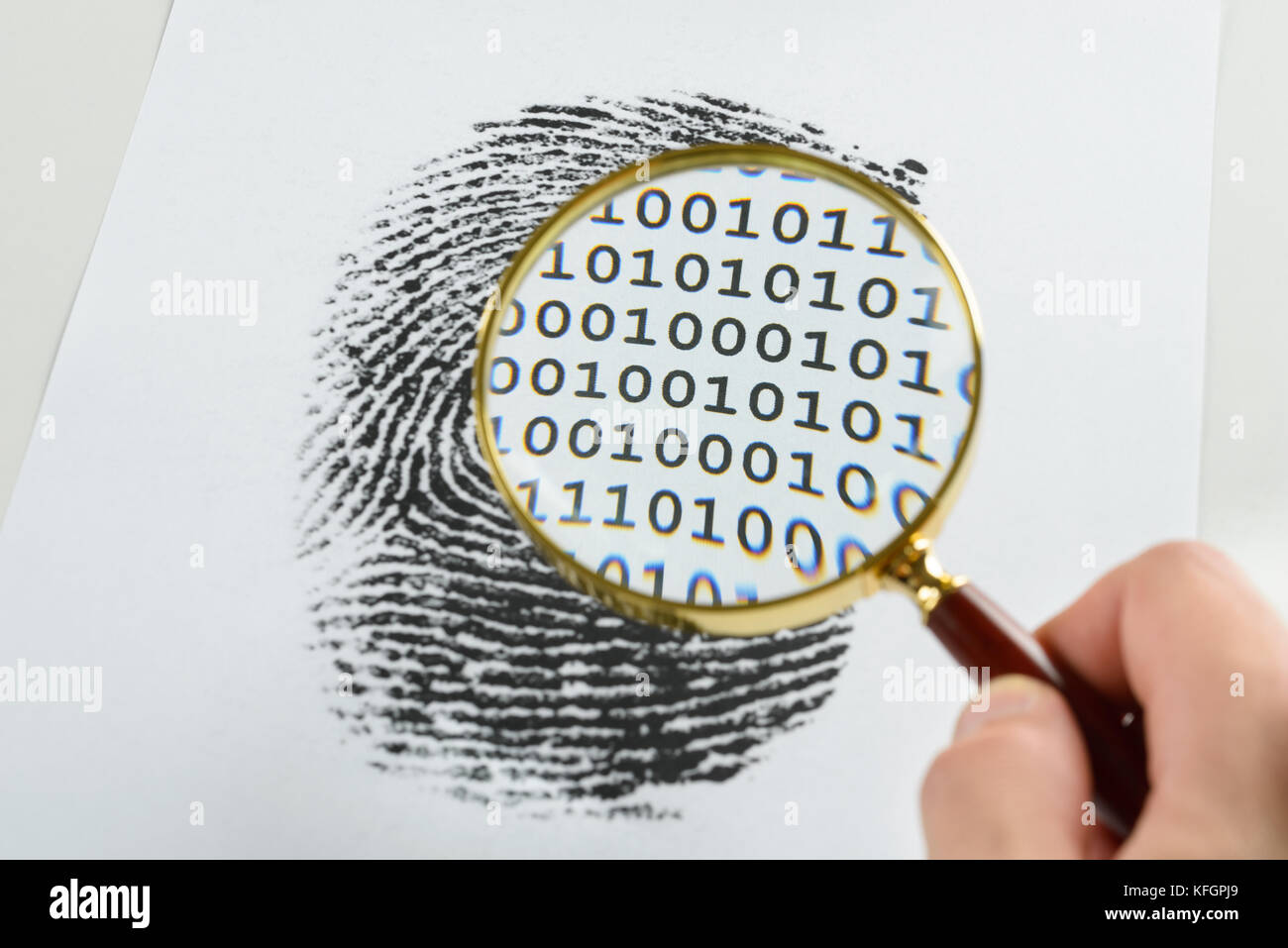 Person Hand mit Vergrößerungsglas über Einem Fingerabdruck enthüllt binären Code im Druck Stockfoto