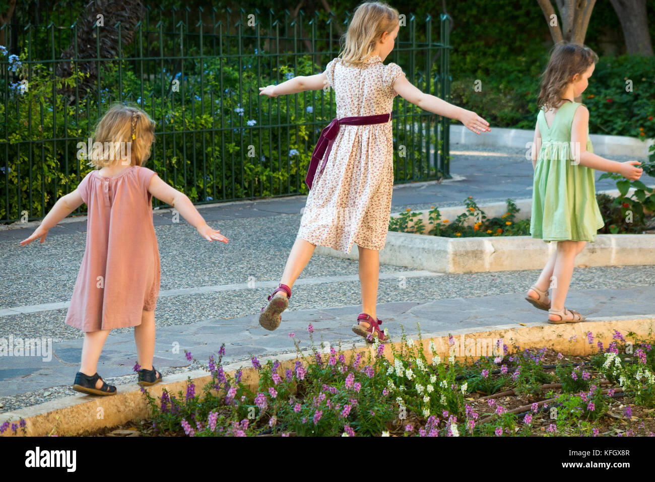 Drei junge Schwestern/Mädchen/Kinder/Kinder/Kind im Alter von 7, 3, & 5 Jahre, auf Familienurlaub Gleichgewicht, Run & Spiel am unteren Barrakka Gardens. Malta Stockfoto