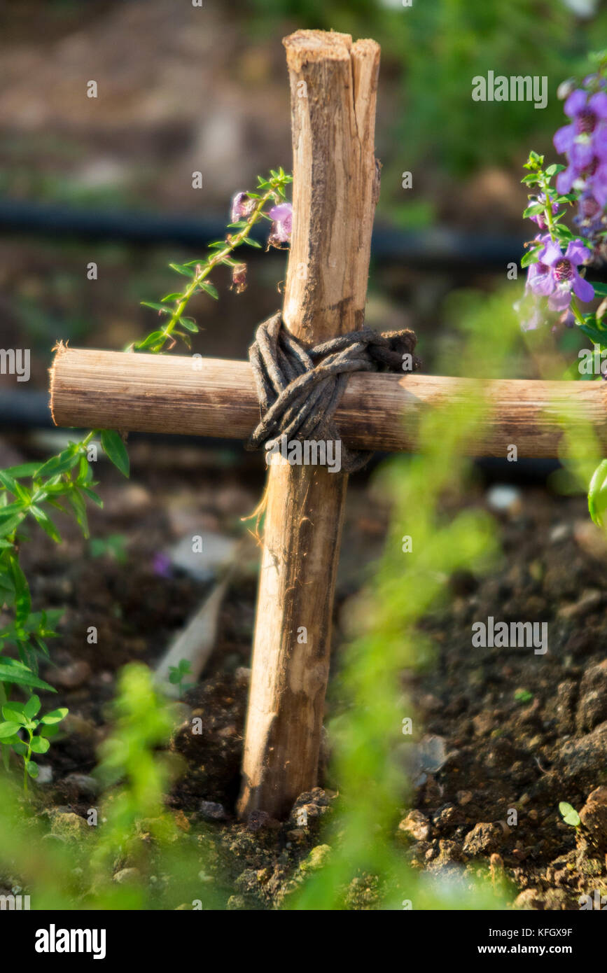 Kleine Grab mit hausgemachten Kreuz/Kruzifix, in einem öffentlichen Garten. Vermutlich das Grab ist eines Haustieres oder geliebten Tier. (91) Stockfoto
