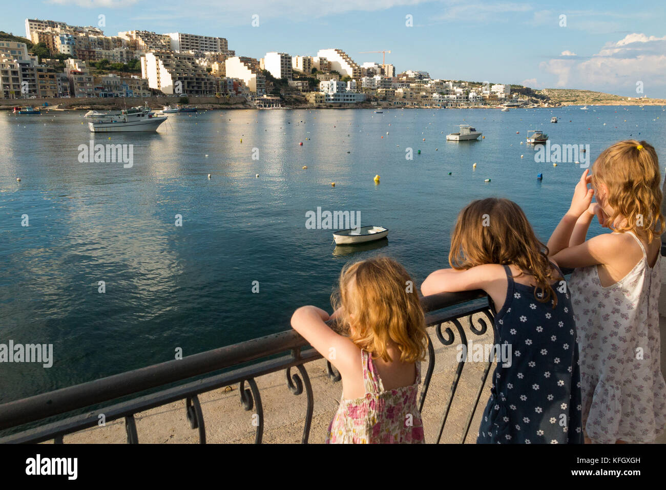 Drei junge Schwestern/Mädchen/Kinder/Kinder/kid Blick über St. Paul's Bay/St. Paul's Bay/Xemxija Bay, im Norden von Malta aus Triq San Pawl. Stockfoto