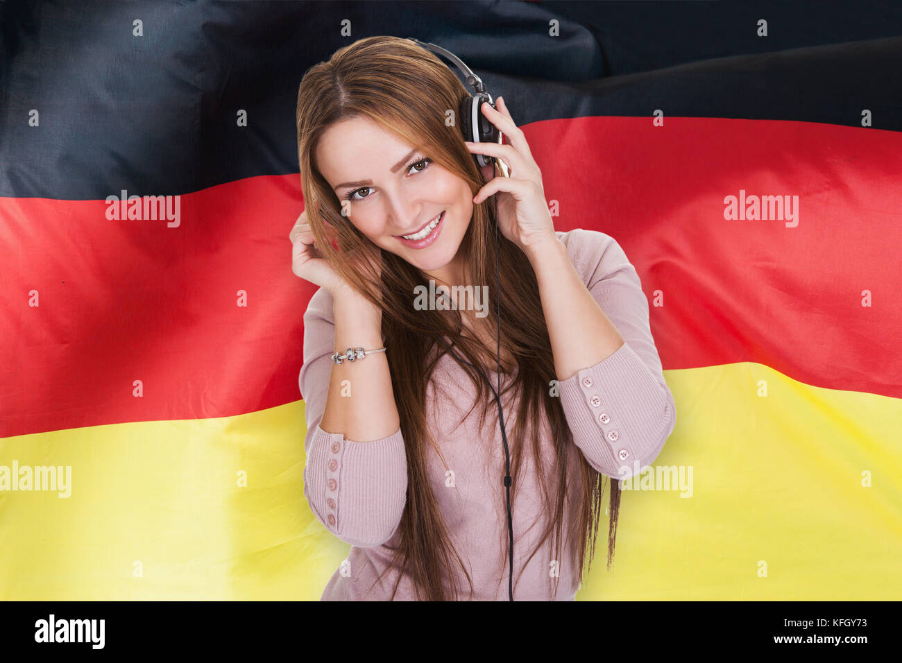Frau hören Deutsch lernen Hörbuch vor der deutschen Fahne Stockfoto