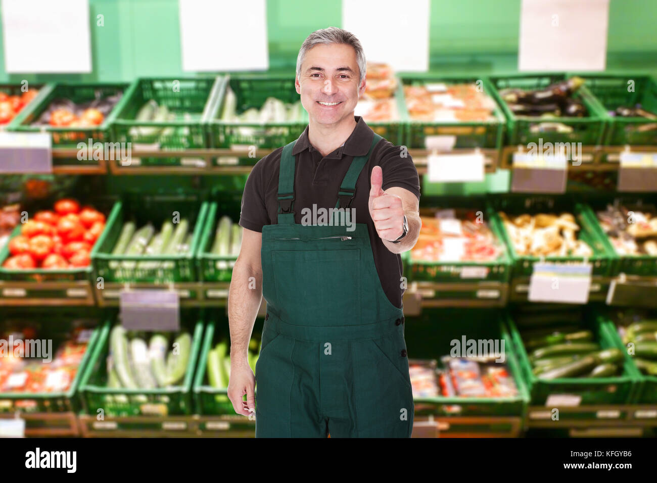 Reife Männliche Verkäuferin Zeigt Daumen Nach Oben Geste Im Supermarkt Stockfoto