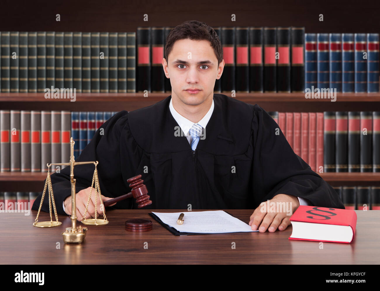 Porträt Eines Jungen Männlichen Richters, Der Im Gerichtssaal Einen Gavel Anstiess Stockfoto