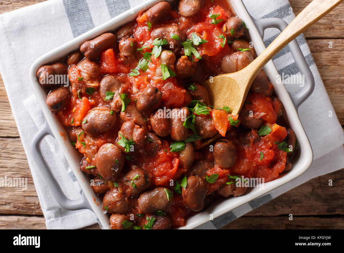 Geschmorte Bohnen in Tomatensoße mit Kräutern und Gewürzen close-up auf dem Tisch. horizontal oben Ansicht von oben Stockfoto