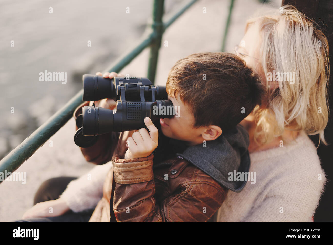 Wenig kaukasischen Jungen mit Fernglas schauen, schauen, schauen, auf der Suche nach an der Mutter Stockfoto